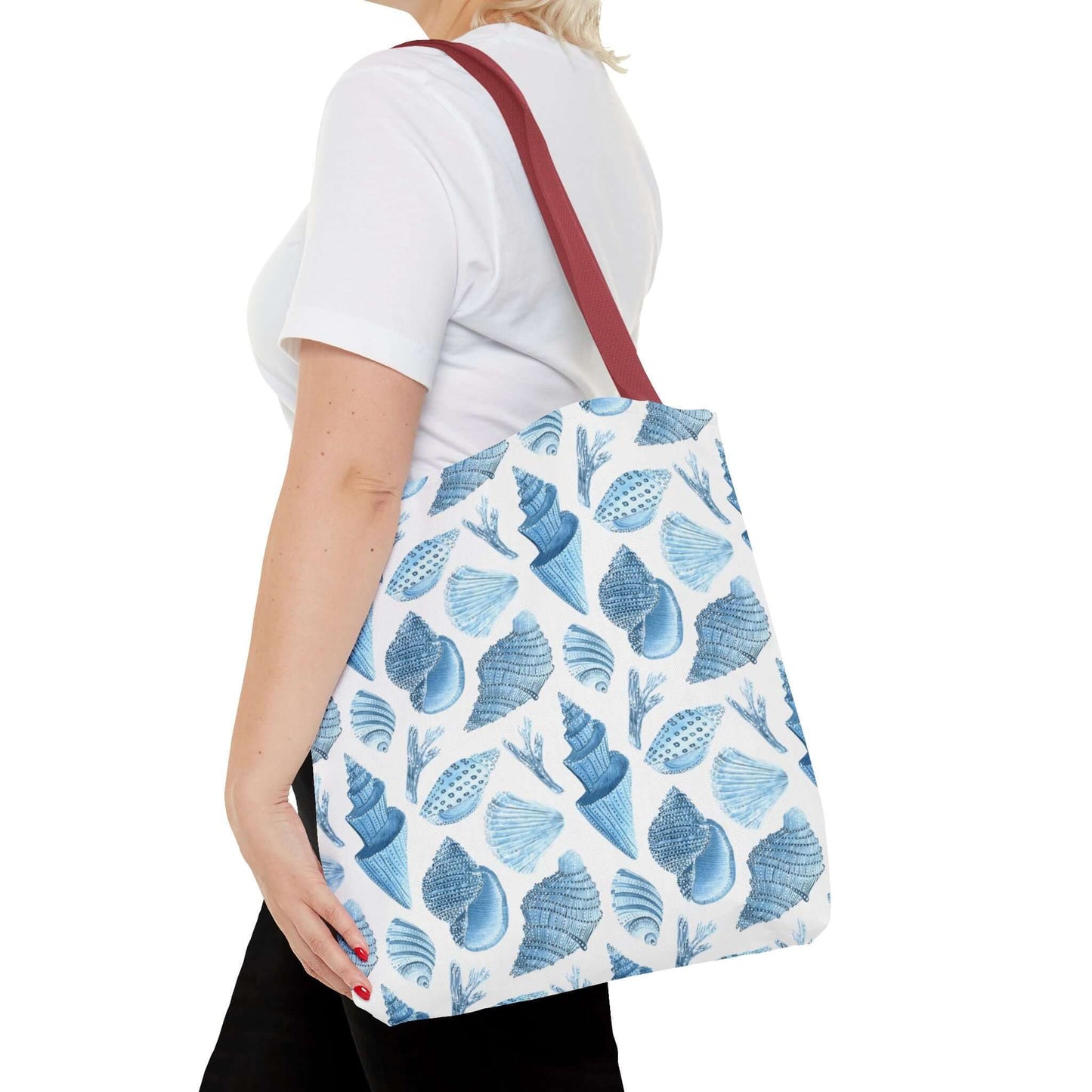 Person carrying a Beachy Tote Bag with ocean seashells print, perfect for eco-friendly outings.