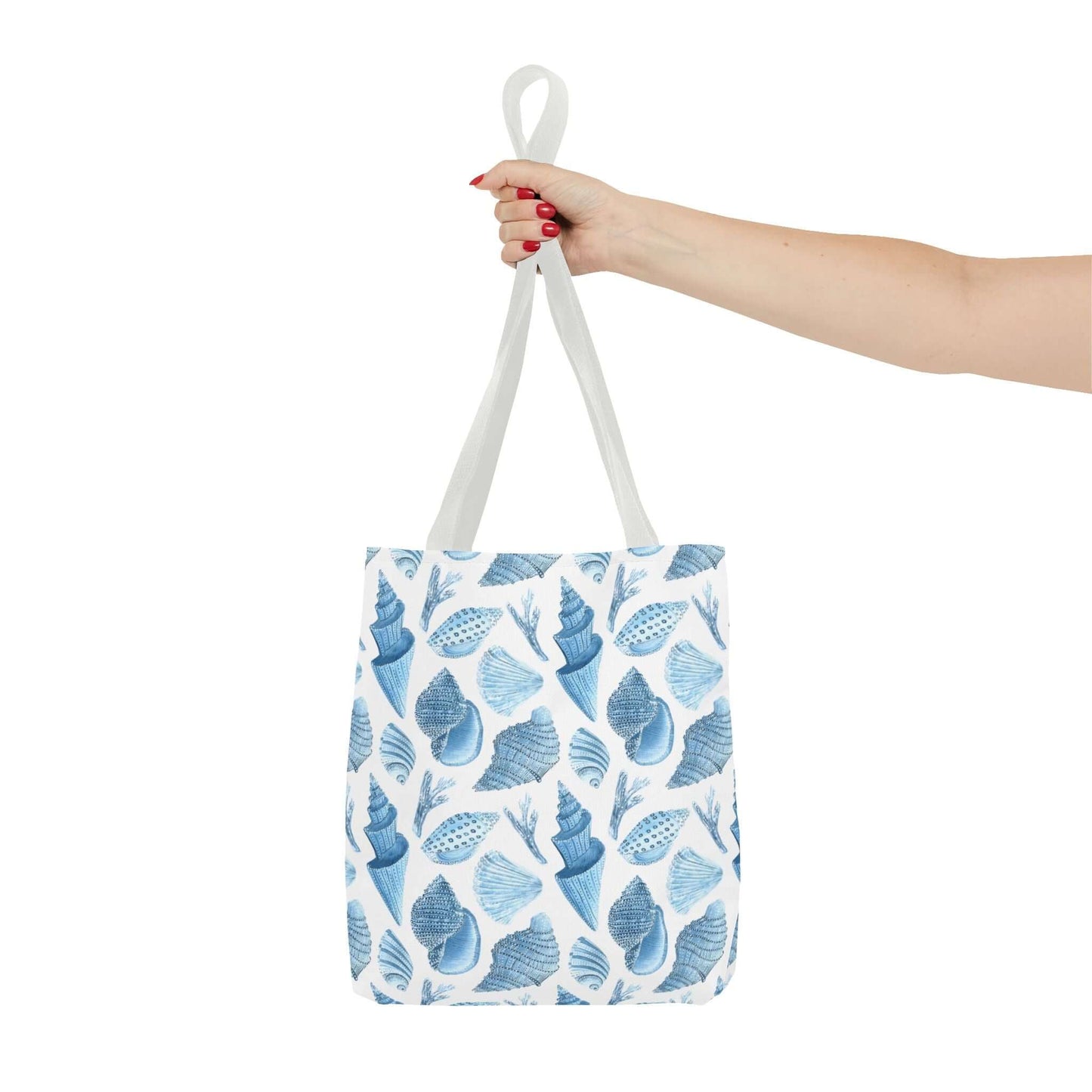 Hand holding a Beachy Tote Bag with a charming ocean seashells print, perfect for eco-friendly outings.