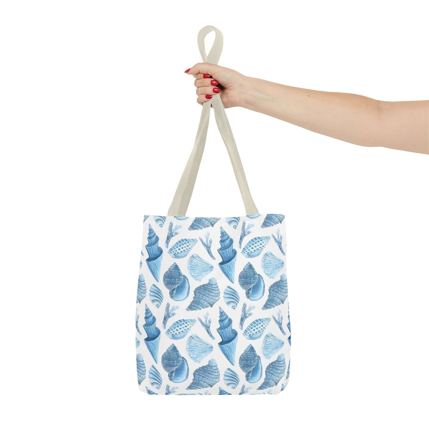 Hand holding a Beachy Tote Bag with ocean seashells print, perfect for eco-friendly shopping and beach trips.