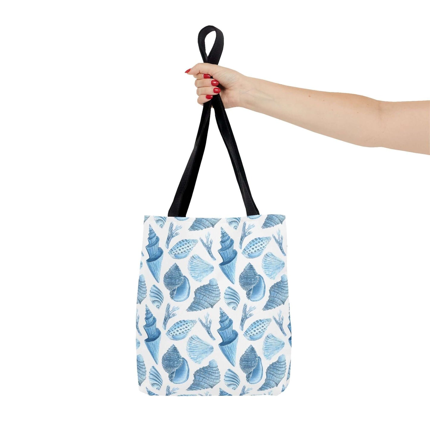 Hand holding a Beachy Tote Bag with a stylish ocean seashells print, perfect for eco-friendly outings.