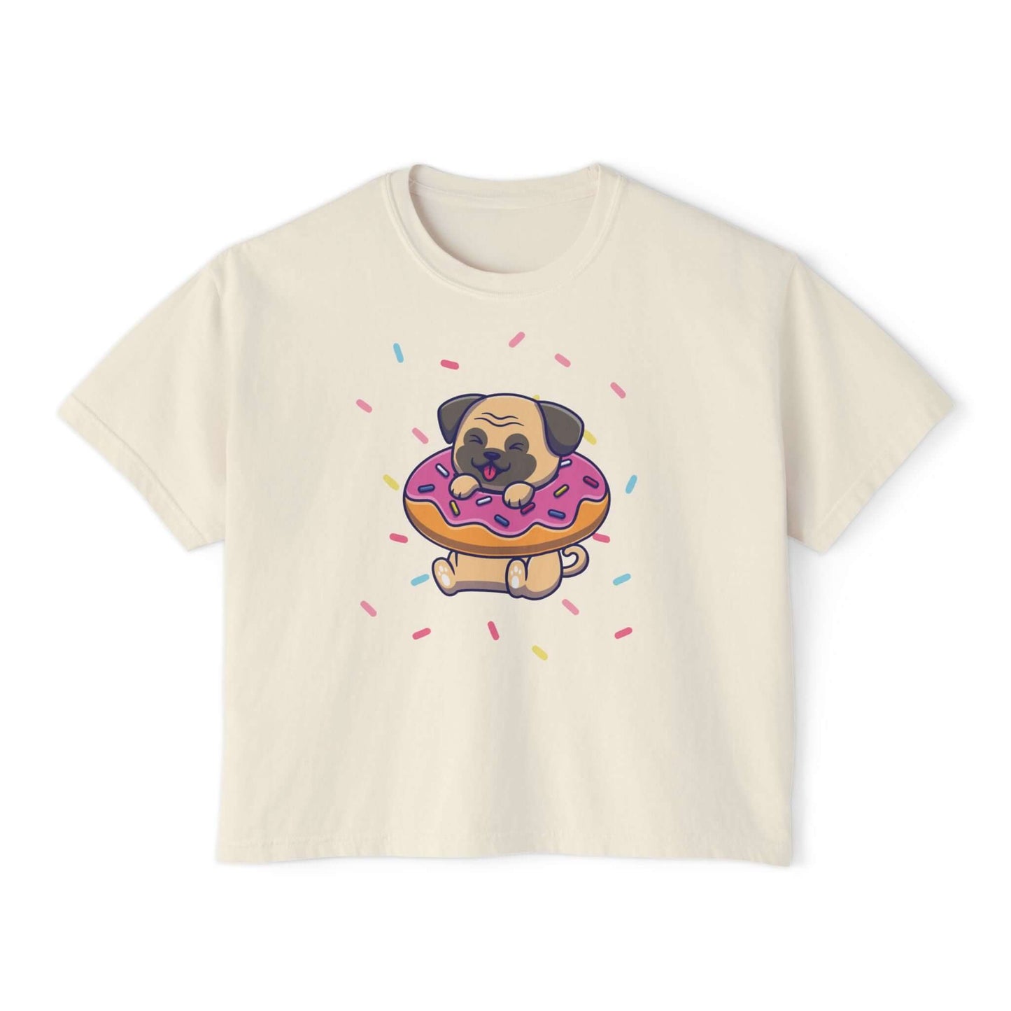 Playful pug graphic on a cream boxy tee, munching a donut with colorful sprinkles, perfect for dog lovers.
