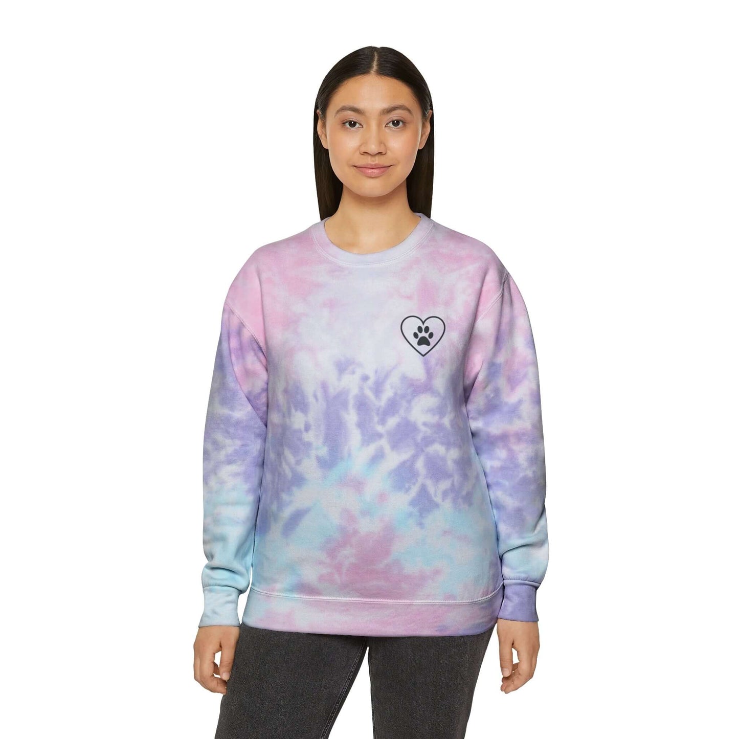 Light Skinned Young Woman Wearing Pink/Purple (Cotton Candy) Tie Dye Sweatshirt showing the front which has a crest design featuring an outline of a heart with a black paw in the center of it. 