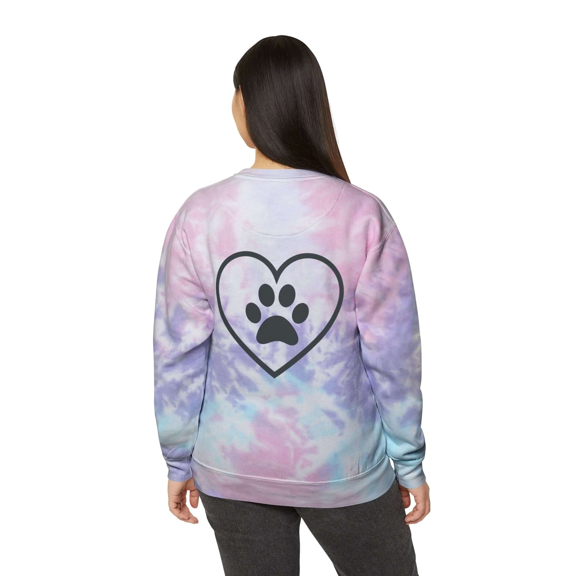 Light Skinned Young Woman Wearing Pink/Purple (Cotton Candy) Tie Dye Sweatshirt showing the back design featuring an outline of a heart with a black paw in the center of it.