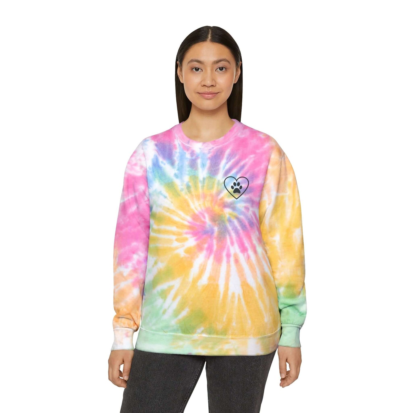 Young Woman wearing a rainbow (Eternity) tie dyed sweatshirt showing the front design featuring an outlined heart with a paw print in the center of it. 